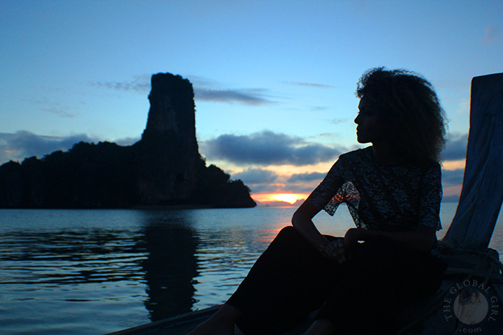 The Global Girl Travels: Ndoema takes in the sunrise on a traditional thai long boat in the Andaman Sea.